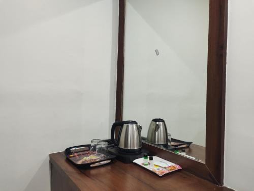 a table with a mirror and a coffee maker on it at Hotel SkyLand in Warangal