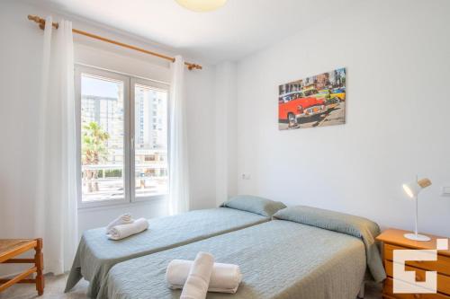 a white bedroom with a bed and a window at Apartamento Racodifach 2B - Grupo Turis in Calpe