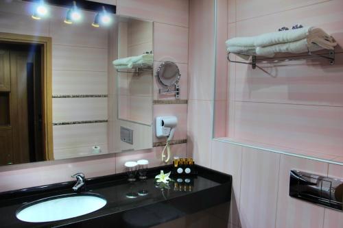 a bathroom with a sink and a mirror at Grand Meteora Hotel in Kalabaka