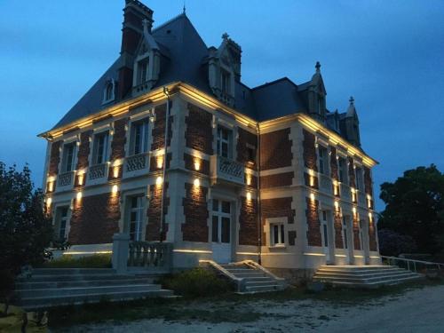a large building with lights on it at night at Château du Mont de Guny 