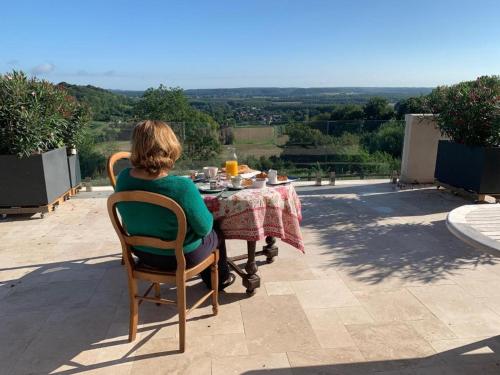 a woman sitting at a table with a table cloth at Château du Mont de Guny in Guny