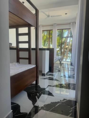 a bedroom with a bed and a glass floor at Coconut Palm beach restaurant and rooms in Dickwella