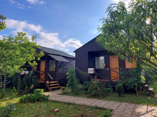 una casa negra con puertas de madera en un patio en sweet village en Tsqaltubo