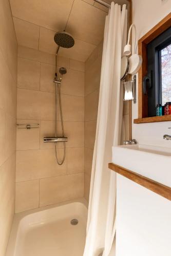 a bathroom with a tub and a sink and a shower at Tiny House Natuur & cultuur nabij Brugge! in Beernem