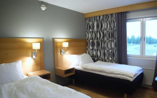 a hotel room with two beds and a window at Aurum Hotel in Skellefteå