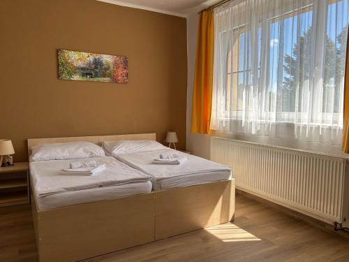 Ce lit se trouve dans un dortoir doté d'une fenêtre et d'une banquette-lit. dans l'établissement Pension Fontana, à Poděbrady
