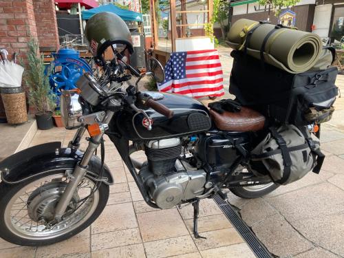 a motorcycle parked on a sidewalk with an american flag at Nawate Guesthouse in Matsumoto