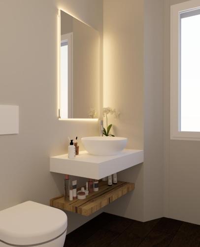 a bathroom with a white sink and a mirror at Vista B&B in Pella
