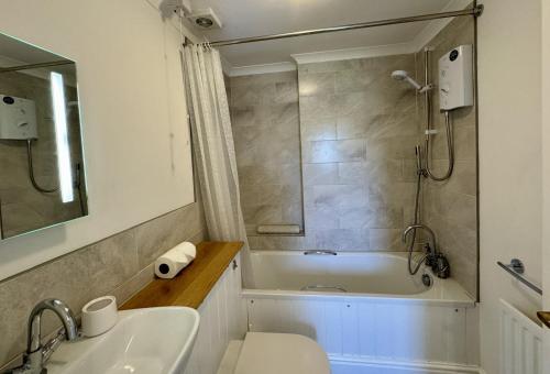 un bagno con vasca, WC e lavandino di Primrose Cottage - South facing cottage in the heart of Dittisham a Dittisham