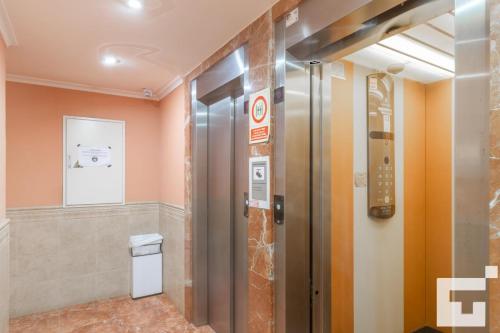 カルプにあるApartamento Topacio III 24A - Grupo Turisのオレンジ色の壁の客室内のエレベーター