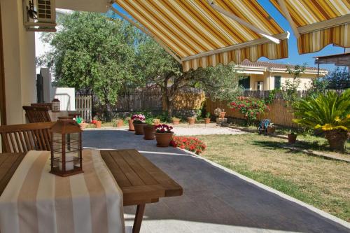 a patio with a wooden table and a patio with plants at Dommu Livia in Lotzorai