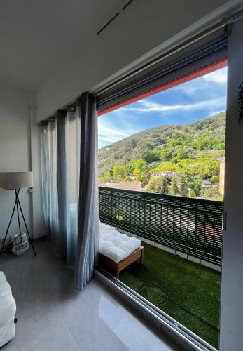 - une chambre avec une grande fenêtre offrant une vue sur la montagne dans l'établissement Superbe 2 pièces avec terrasse, à Menton