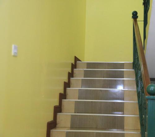 a staircase in a room with yellow walls at ACK Guest House Nairobi in Nairobi