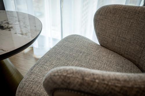 a chair sitting next to a table and a glass table at Jeju Bolton Hotel in Jeju