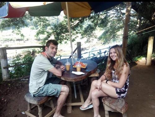 a man and woman sitting at a table under an umbrella at Nice Place Kandy in Kandy