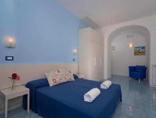 una camera con un letto blu con due cuscini sopra di Hotel Imperamare a Ischia
