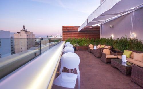 a rooftop patio with couches and chairs on a building at Business Hotel in Tunis