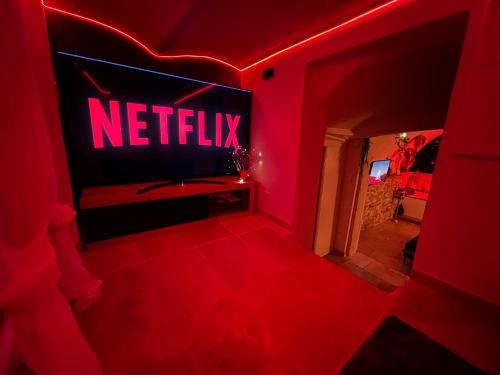 a red room with a netflix sign on a tv at Les Bains d'Aphrodite in Auriol