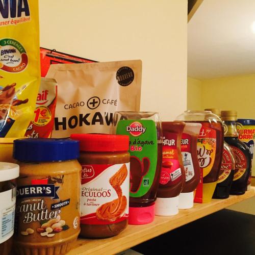 a shelf with jars of peanut butter and other food items at Résidence Thibaud in Toulouse