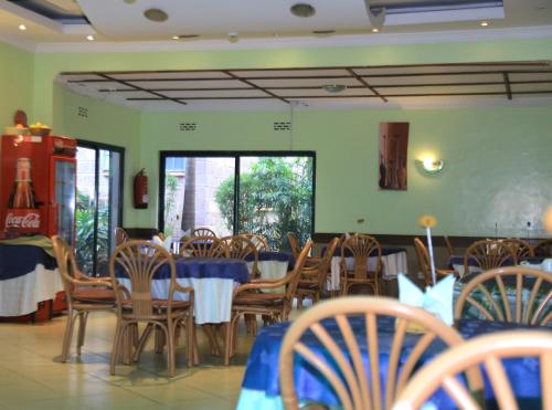 a dining room with a table and chairs and tables and chairsktop at ACK Guest House Nairobi in Nairobi