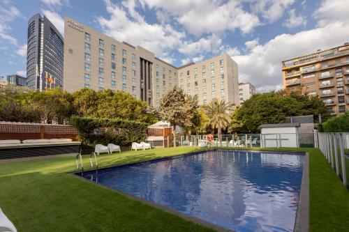 a large swimming pool in a city with buildings at Primus Valencia in Valencia