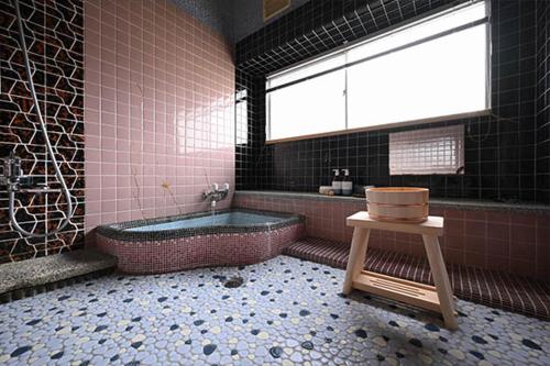baño con bañera, lavabo y ventana en Hideaway Tabaki en Echizen