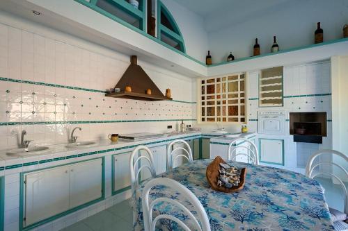 a kitchen with a table and chairs and a sink at Villa Galatea al mare - Tonnarella in Mazara del Vallo