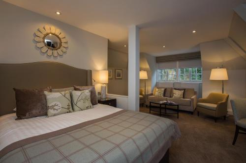 a bedroom with a bed and a couch and a mirror at Crathorne Hall in Yarm