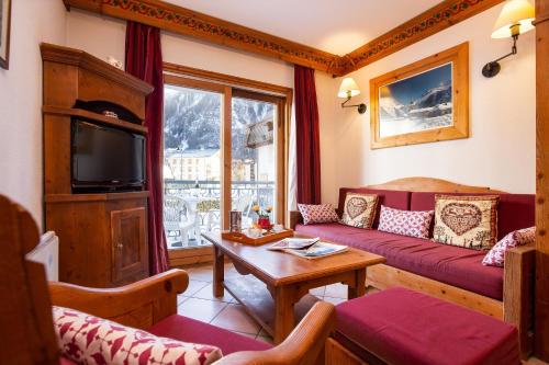 ein Wohnzimmer mit einem Sofa und einem TV in der Unterkunft Résidence Le Cristal - Grands Montets 8 - Happy Rentals in Chamonix-Mont-Blanc