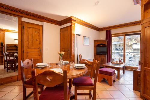 a kitchen and dining room with a table and chairs at Résidence Le Cristal - Grands Montets 8 - Happy Rentals in Chamonix