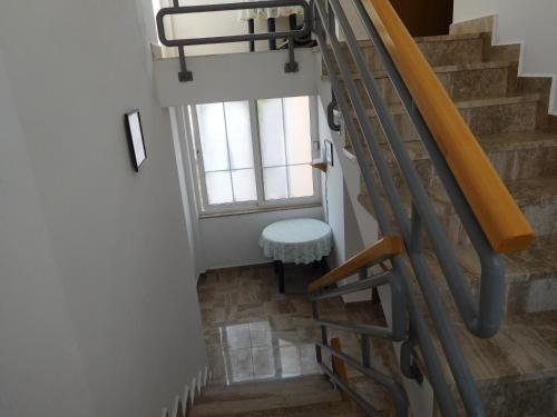 un escalier avec un tabouret et une fenêtre dans l'établissement Studios Timing, à Orebić