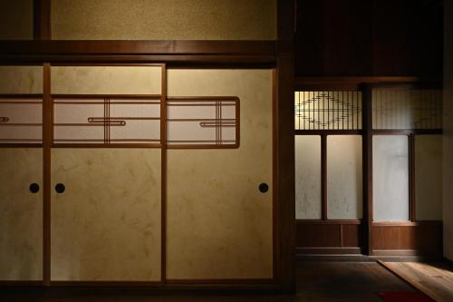 Pokój z dwoma szklanymi drzwiami i oknem w obiekcie Hideaway Tabaki w mieście Echizen