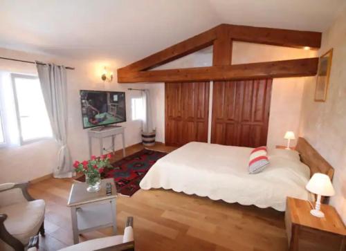 - une chambre avec un grand lit et une télévision dans l'établissement Villa Claramande, à Fréjus