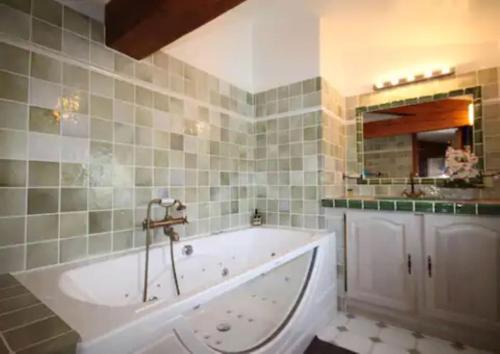 une salle de bain avec une grande baignoire et un miroir dans l'établissement Villa Claramande, à Fréjus