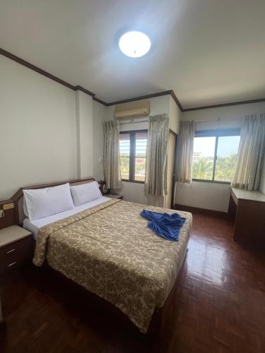 a bedroom with a bed with a blue shirt on it at Muang Thong Family Suite Hatyai in Hat Yai