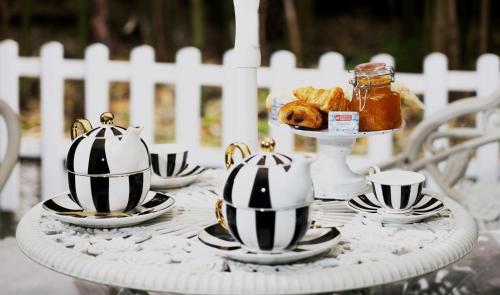 una mesa con tazas de té y cruasanes en ella en Les Canoubiers Luxe et sérénité au cœur de Saint-Tropez Suites spacieuses avec jardin enchanteur, en Saint-Tropez