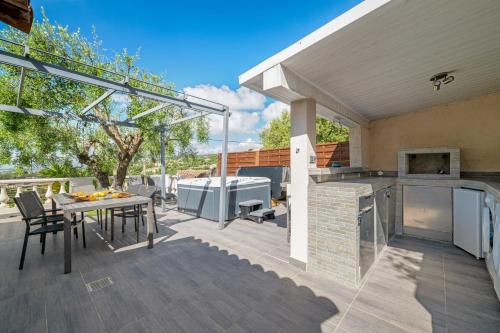 an outdoor patio with a table and a grill at Villa vue mer, terrasse et spa in Nice