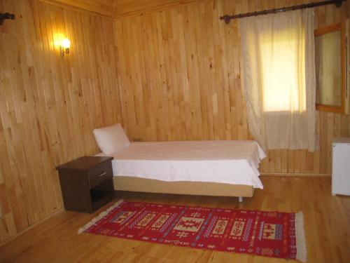 a bedroom with a bed and a window and a rug at Cirali Armira Bungalow in Cıralı