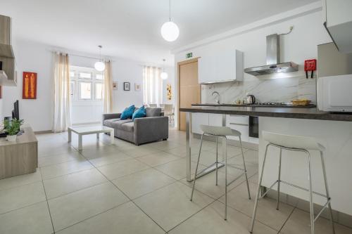 eine Küche und ein Wohnzimmer mit einem Tisch und Stühlen in der Unterkunft Superb 3BR apt close to seafront in Gżira