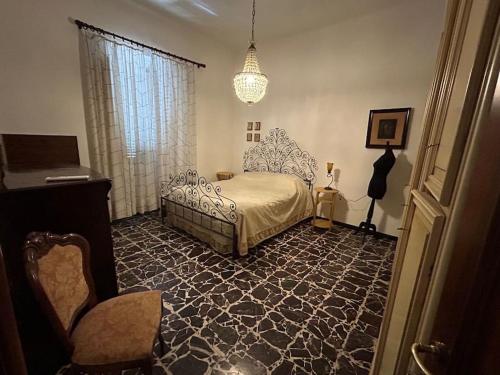 a bedroom with a bed and a chair and a chandelier at Villa Olga in San Vincenzo