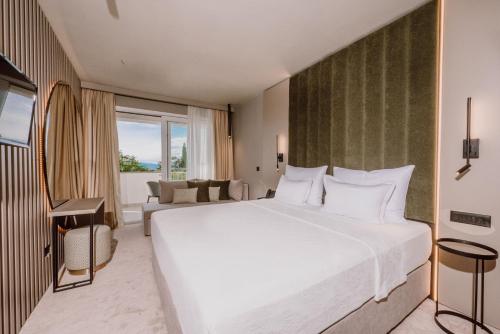 um quarto com uma grande cama branca e uma grande janela em Hotel Malin em Malinska