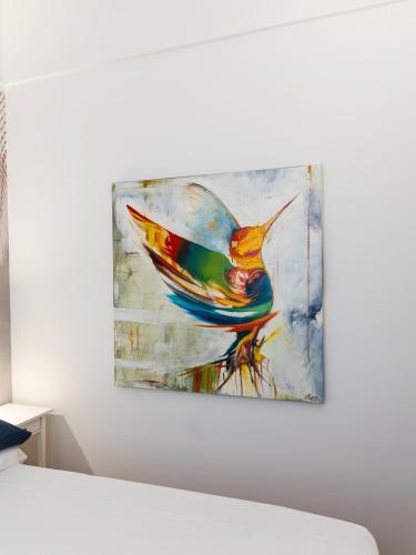 a painting of a bird hanging on a wall at Casa Misette 200mq a due passi dal mare in Alassio
