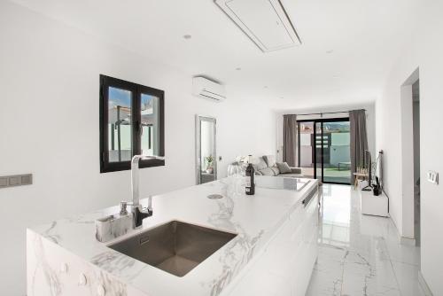 a white kitchen with a sink and a counter at Sunset House Maspalomas in Playa del Ingles