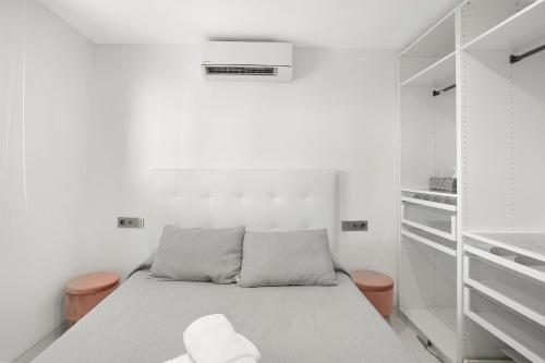 a white room with a bed and white shelves at Sunset House Maspalomas in Playa del Ingles