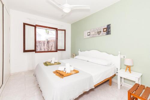 a white bedroom with a bed and a window at Biniforcat in Cala en Forcat