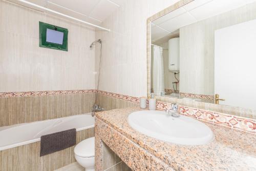 a bathroom with a sink and a toilet and a mirror at Biniforcat in Cala en Forcat