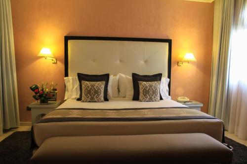 un grande letto in una camera d'albergo con due lampade di Berbère Palace a Ouarzazate