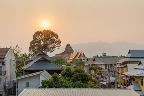 a view of a city with the sun setting in the background at Chala Number 2 Art and Gallery in Chiang Mai