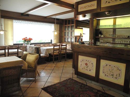 a restaurant with a bar and a table and chairs at Hotel Vajolet in Mazzin