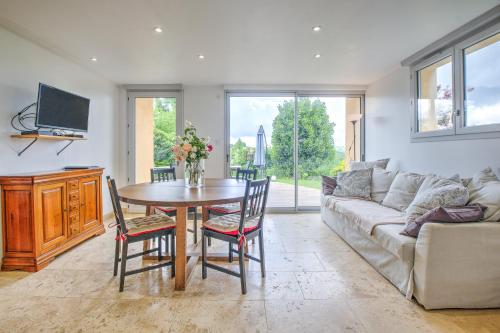 a living room with a table and a couch at Gite Deodatus avec piscine in Cladech
